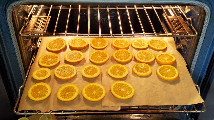 lay orange slices on parment paper covered oven rack