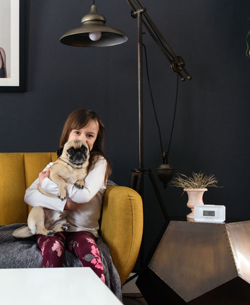 Girl with pug on yellow couch