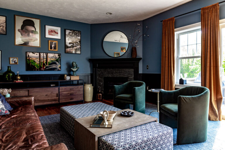 Blue and black living room with corner fireplace and large mirror.