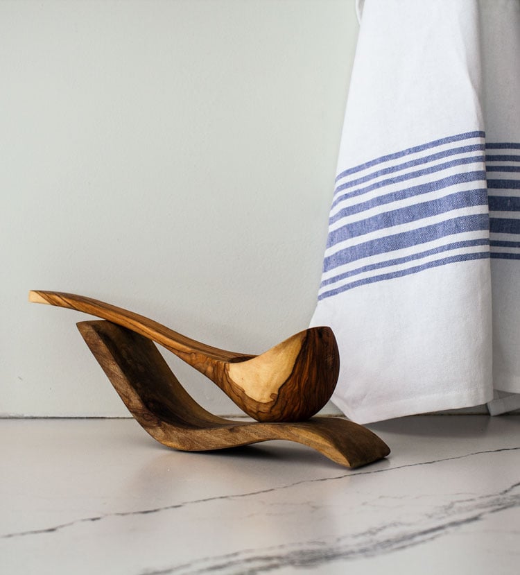 Blue and white striped dish towel with olive wood serving spoon.