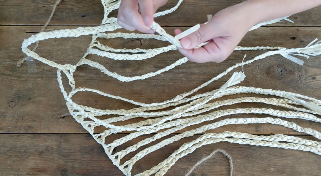 Braid 20 ropes of raffia using bundles of 3 - 4 strands.