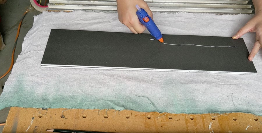 wrap your pinboard in fabric and attach using hot glue