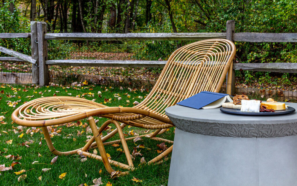 Rattan chair on the edge of the woods with table and snacks.