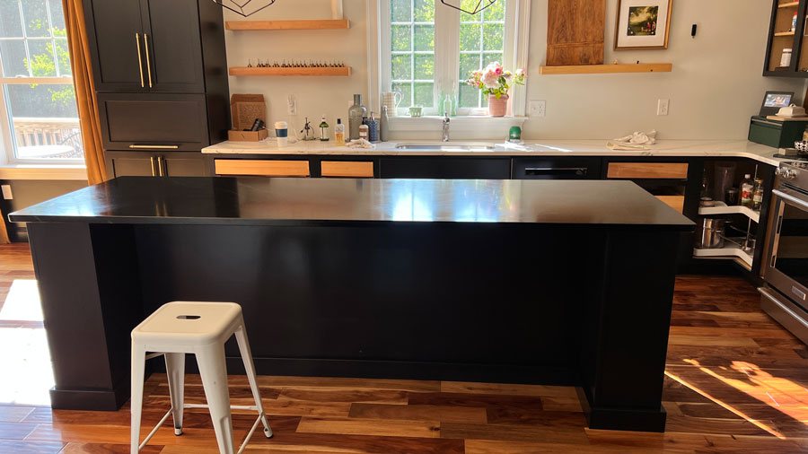 Black kitchen island with white stool in front