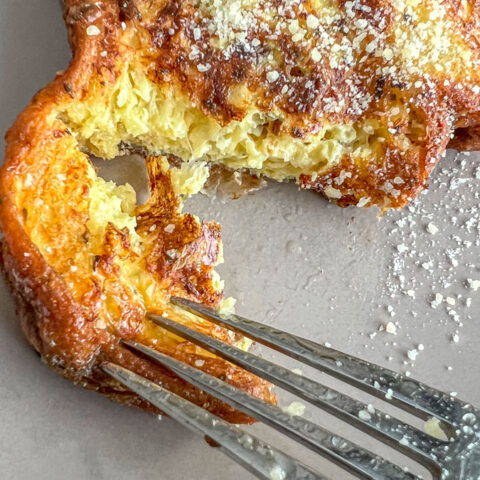 Fork cutting into a slice of croissant french toast.