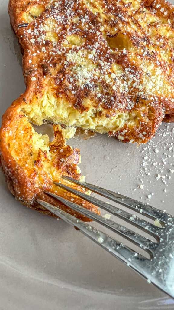 Fork cutting into a slice of croissant french toast.