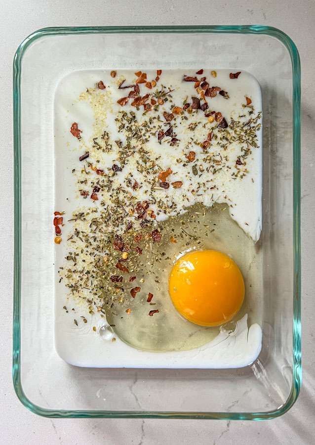 Egg, milk, crished red pepper flakes, oregano, salt, and garlic powder in a small dish.