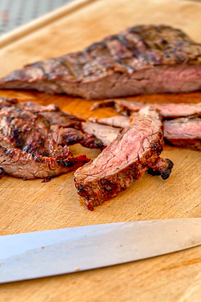 Sliced steak on a cutting board.