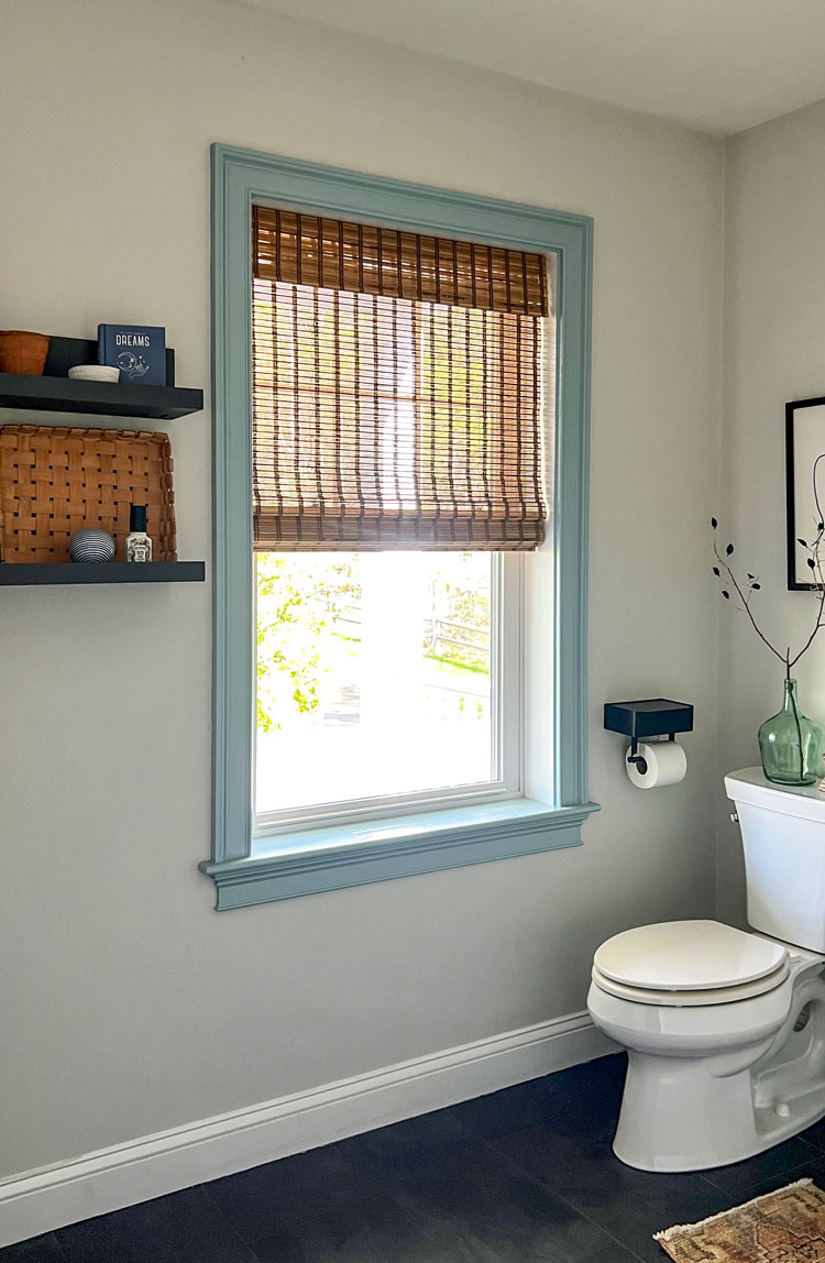 Window with a bamboo blind in a small bathroom.