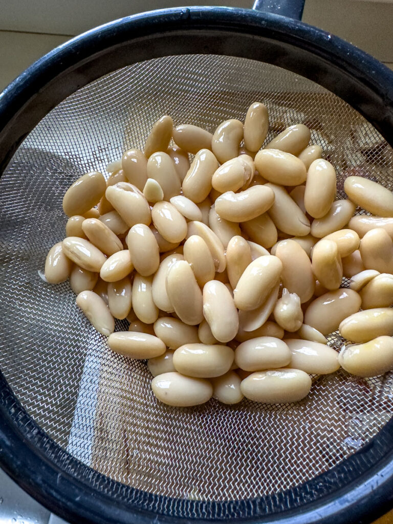 Cannelini beans draining in a strainer.