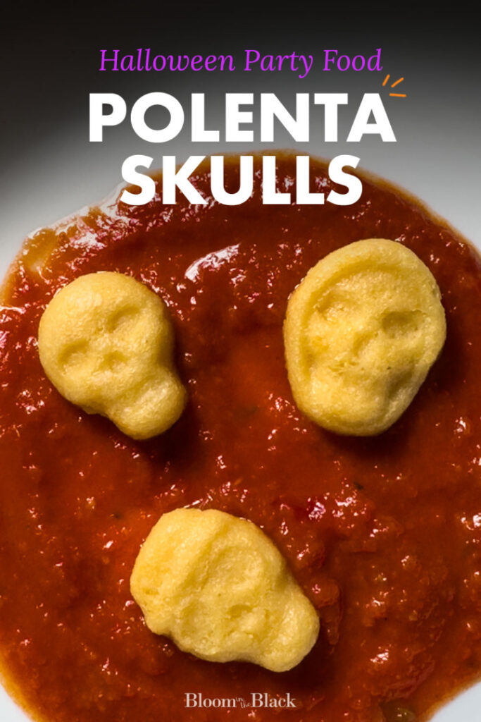 Three baked polenta skulls sitting in a pool of marinara sauce. The text reads, "Halloween Party Food: Polenta Skulls."