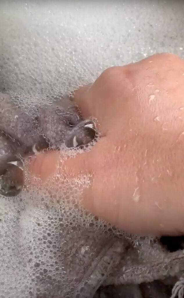 Hand in a bowl of soapy water.
